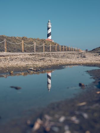 Sidewalk located against hill and lighthouse