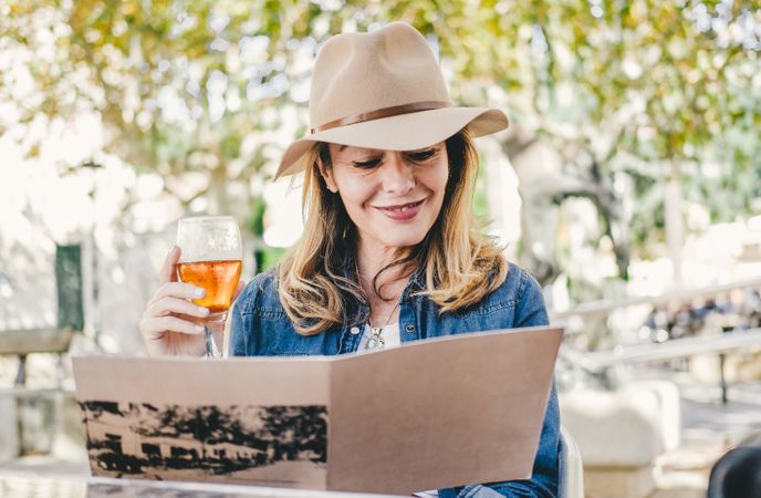Woman sitting outside cafe drinking beer
