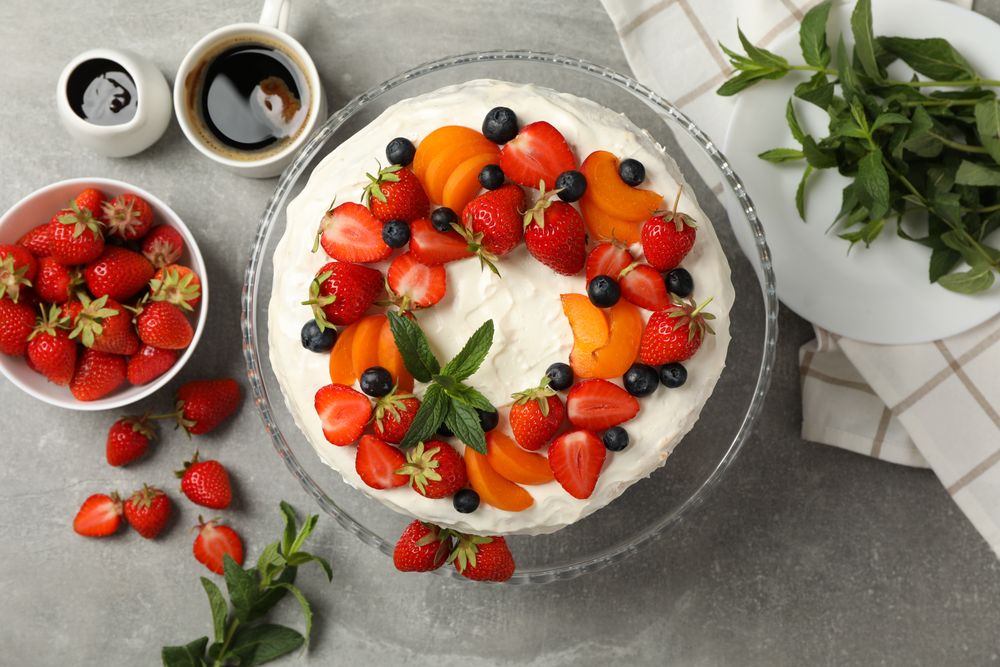 Composition with delicious berry cream cake on gray table. Tasty dessert
