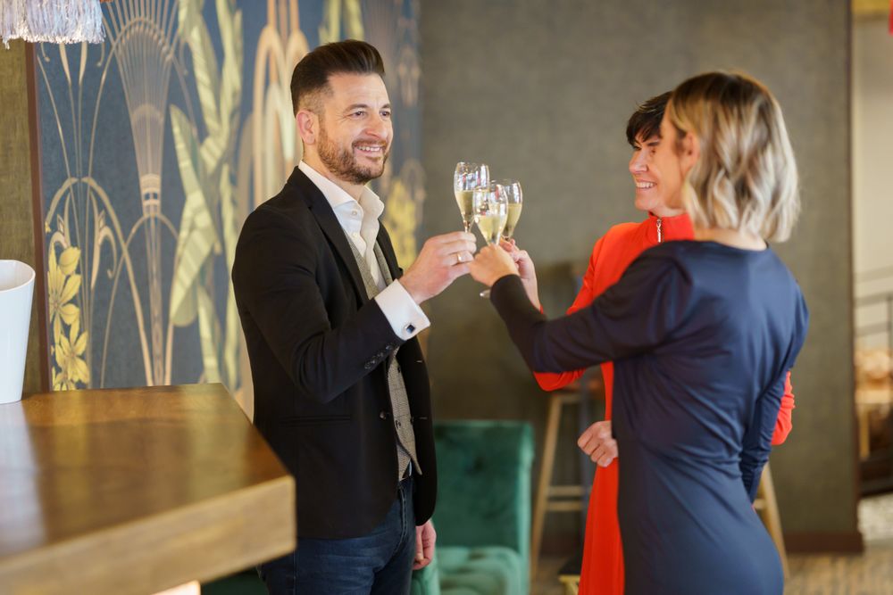 Three well dressed friends toasting with Prosecco or cava