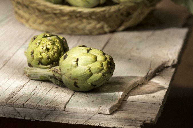 Green artichoke on wooden table