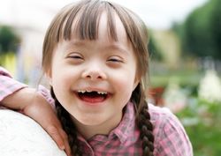 Closeup of a happy girl in a pink checkered shirt and braided hair