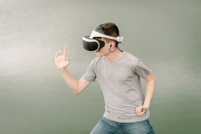 Young teenager with virtual reality glasses outdoors