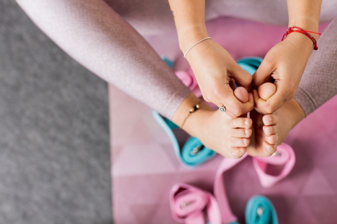 Faceless woman practicing yoga on pink mat