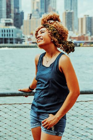 Smiling Black woman at waterfront in Brooklyn with Hudson River in background