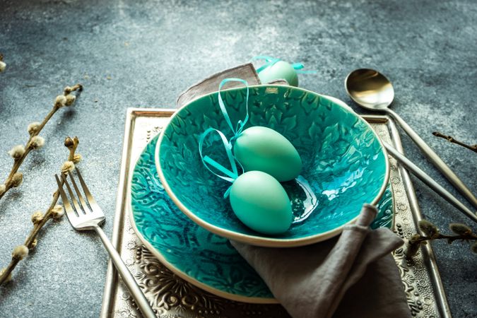 Easter holiday table setting with teal bowl and teal decorative eggs