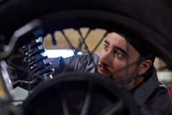 Focused man repairing motorcycle in garage