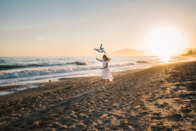 Adorable girl playing with ribbon on seaside