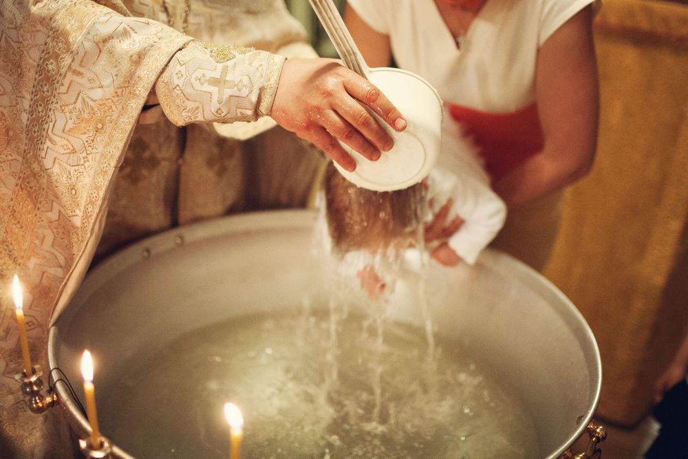 Cropped image of priest baptizing a baby