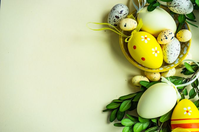 Easter card concept with yellow decorative Easter eggs in bowls on pastel background