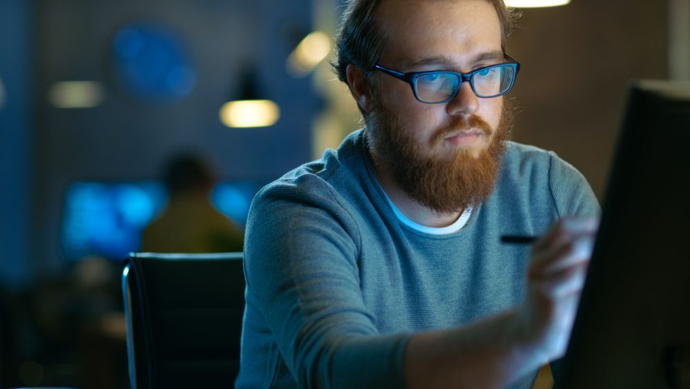 Talented Concept Artist Drawing on a Digital Pen Display Tablet While Sitting at His Working Place in Modern Loft Office
