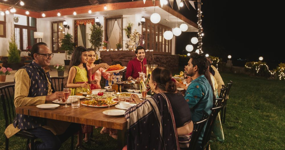 Big Indian Family Celebrating, Gathered Together at the Table in Backyard Garden for Dinner.