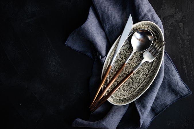 Top view of thin cutlery set on ornate plate