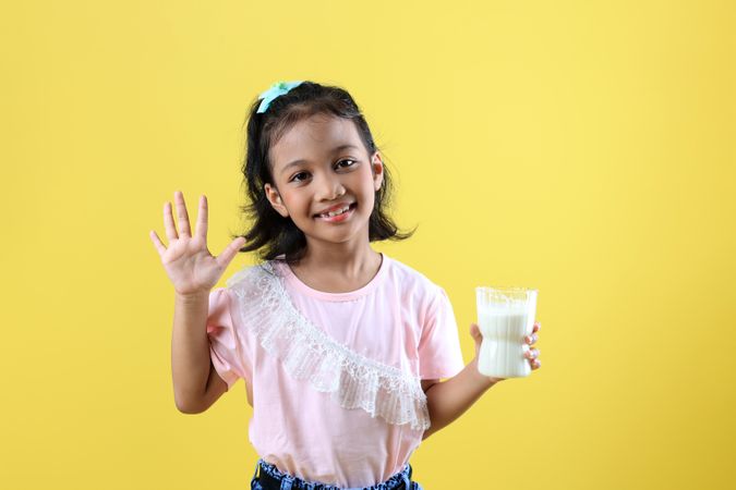 Happy Asian Kids Say Hi and Holding A Glass of Milk