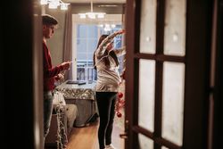 Young couple expecting baby arranging Christmas tree at home