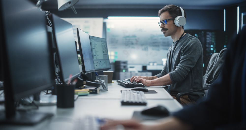 System Administrator Working in a Research E-Business Facility on a Desktop Computer.