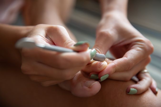 Woman Doing Pedicure at Home Removing Cuticles