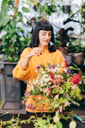 Woman putting together a flower bouquet.