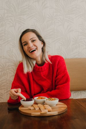 Woman smiling eating assorted food at table
