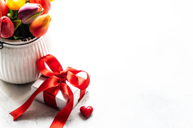 Small vase of tulips, heart ornaments and small gift