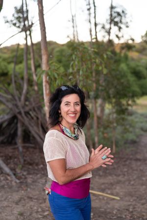 Happy woman smiling at the camera outside in a tree grove in a canyon