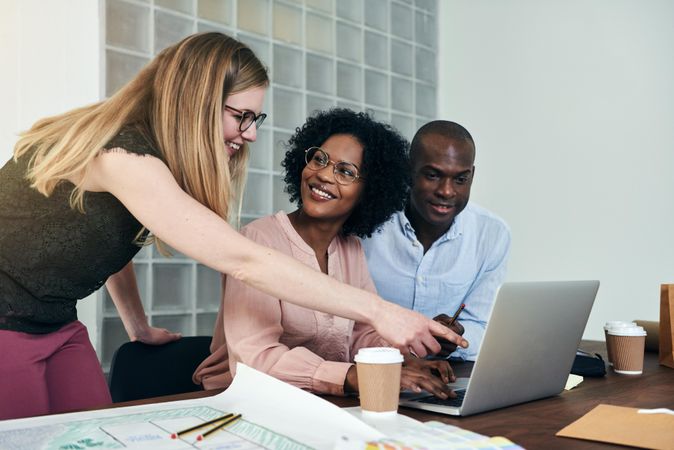 Multi-ethnic group of colleagues discussing work over a laptop