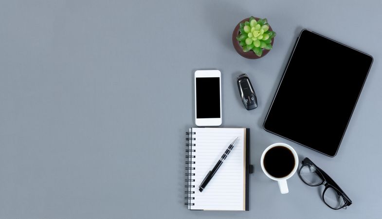 Flat lay view of gray desk with functional modern wireless technology