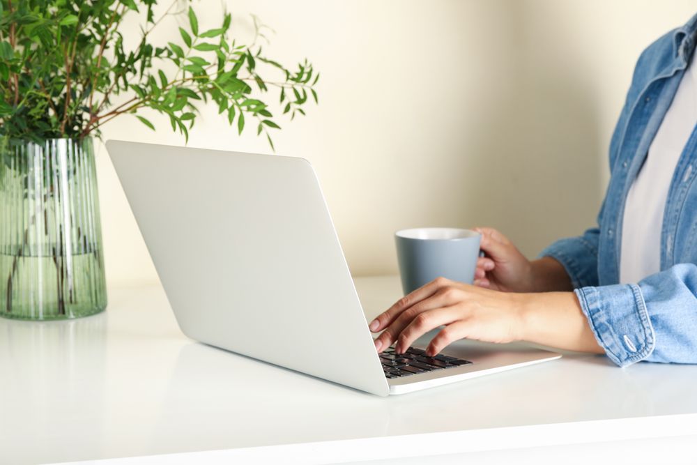 Young woman working on laptop and drink coffee