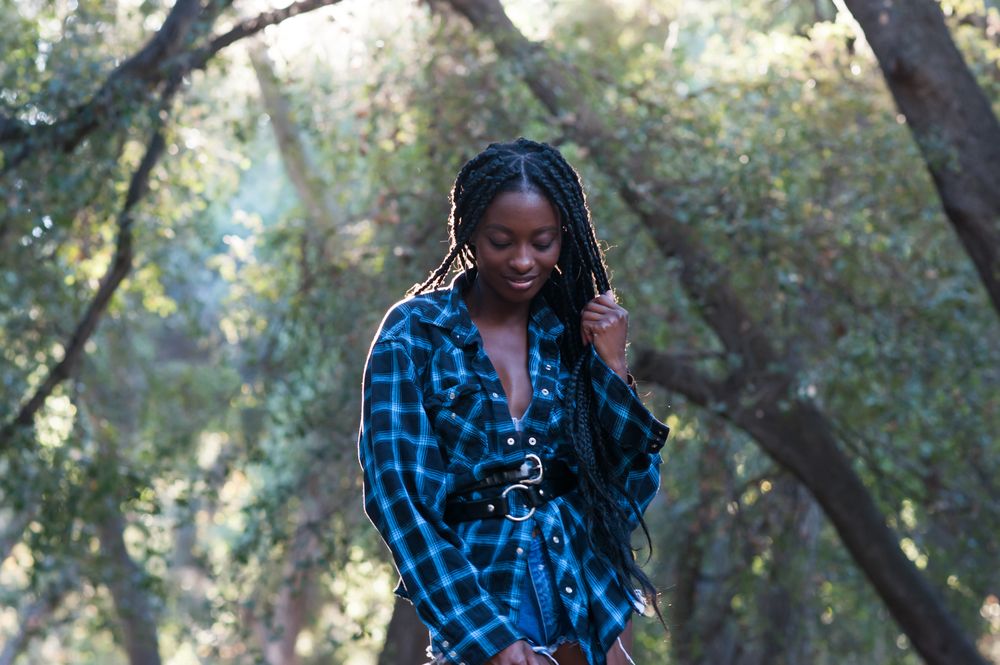 Portrait of Black woman with box braids standing in the woods