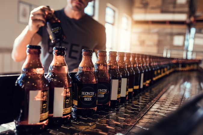 Close up of bottled beer beverages on conveyor belt