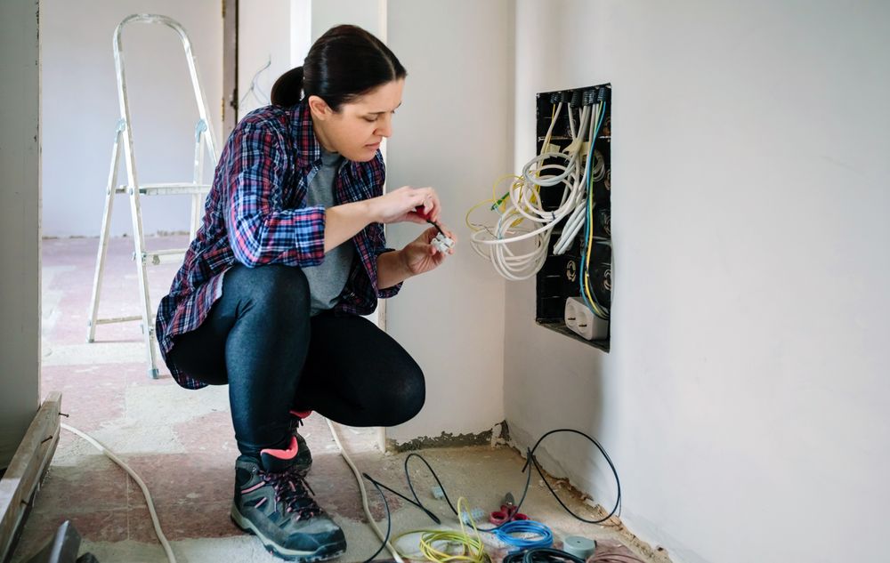 Technician with screwdriver and terminal strip installing telecommunication box