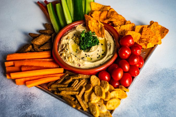 Traditional hummus dish with veggies for dipping served on board