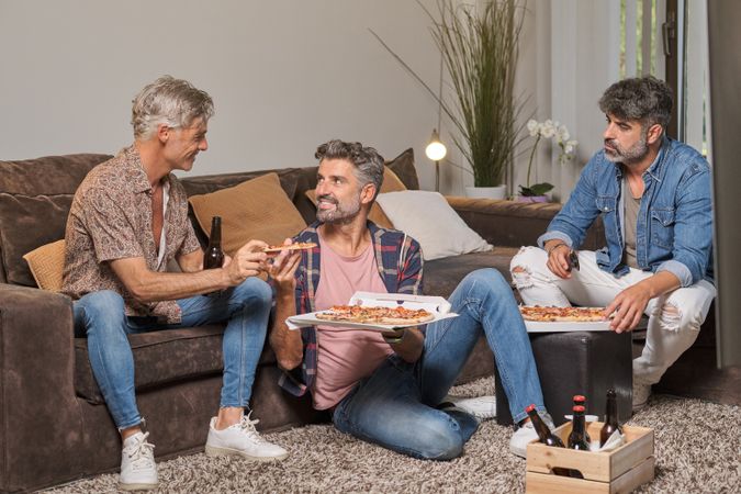 Group of friends eating pizza at home