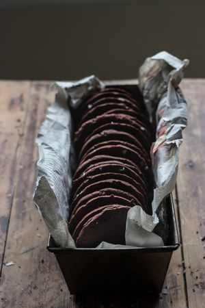 Dry olive twig near chocolate cookies and towel