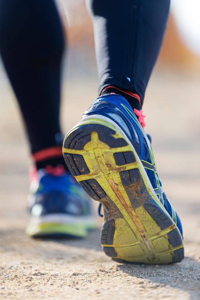 Close up of soles of trainers of person running