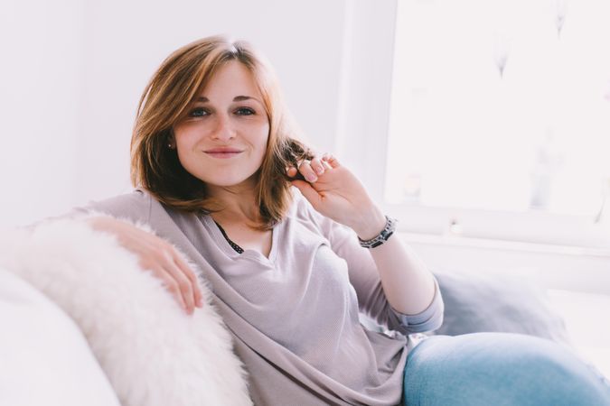 Portrait of a happy young woman sitting on a couch