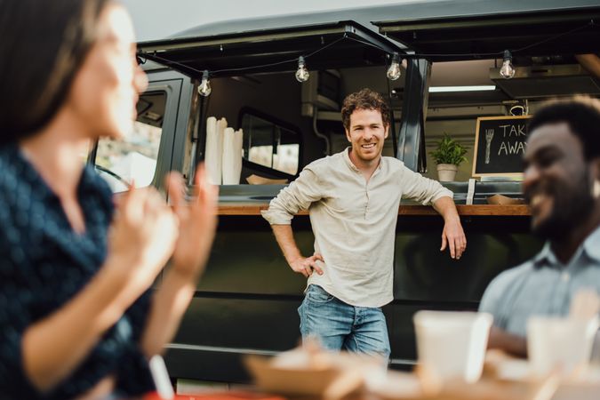 Multiracial friends having fun eating at food truck outdoor