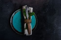 Holiday table setting with decorative fir wrapped with cutlery