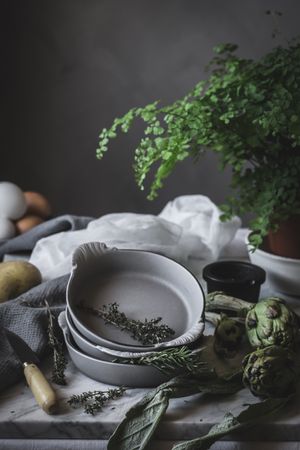 Eggs and different herbs in bowls placed on rustic table