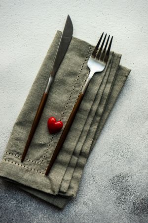 Heart decoration on grey napkin and silverware