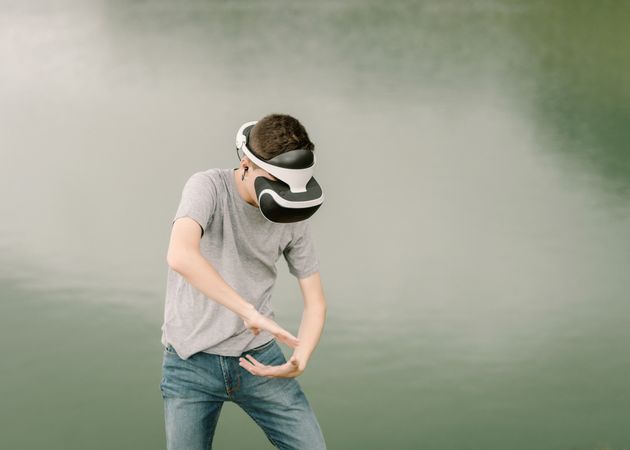 Young teenager with virtual reality glasses outdoors