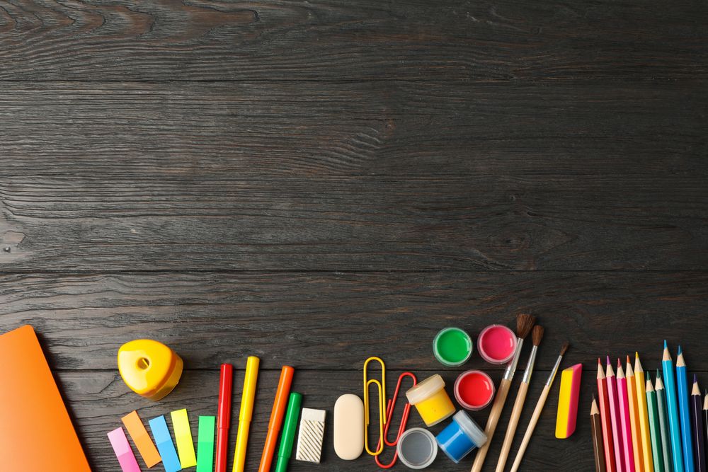 Flat lay composition with school supplies on wooden background, space for text