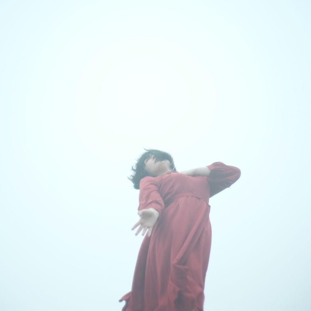 Woman in red dress dancing on seashore