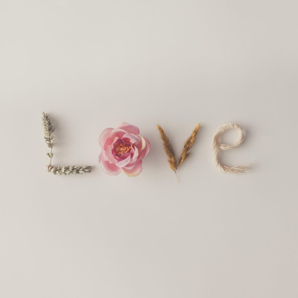 Word LOVE made out of flowers and dried branches