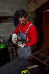 Bearded mechanic examining angle grinder