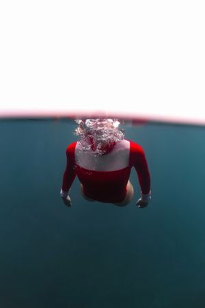 Woman diving in blue waving water