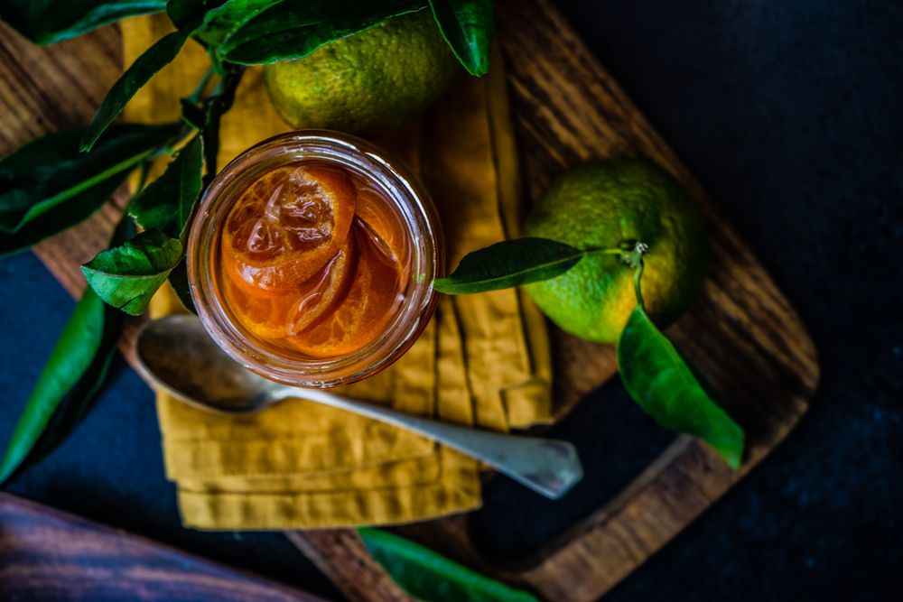 Top view of tangerine jam and fresh fruits