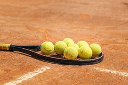 Tennis racket and ball on a dirt court