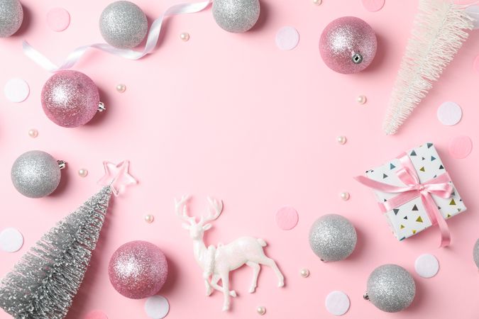 Christmas balls and presents on pink background, space for text