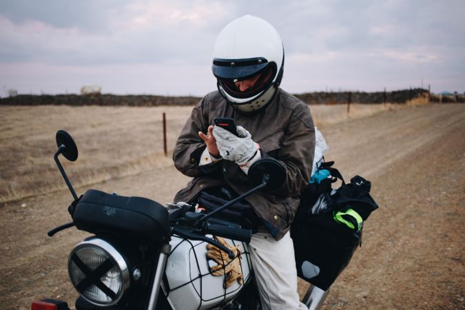 Man checking phone on motorcycle